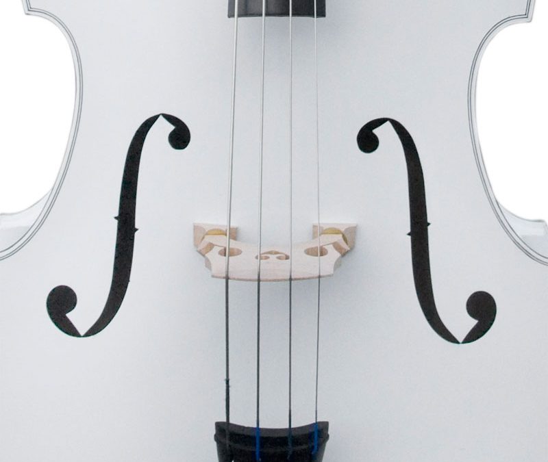 Close-up of a white violin's strings and bridge.