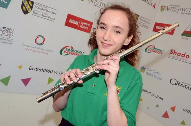 Young musician holding a flute, smiling.